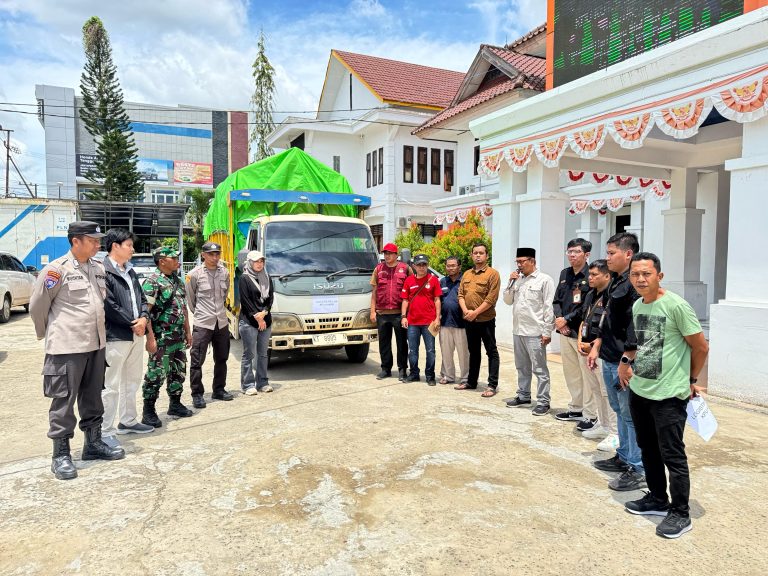 Caption: Petugas KPU Kukar melepas truk pengangkut logistik PSU 2025 menuju kecamatan terjauh. Pengiriman dilakukan lewat jalur darat dan air. (KPU Kukar)