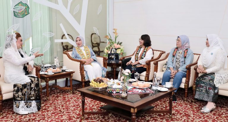 Caption: Ketua PKK Kaltim Syarifah (kebaya putih mengangkat tangan), Ketum TP PKK Pusat Ibu Tito (mengenakan batik biru dan syal manik), di VIP Room Bandara Balikpapan, Senin (21/4/2025).